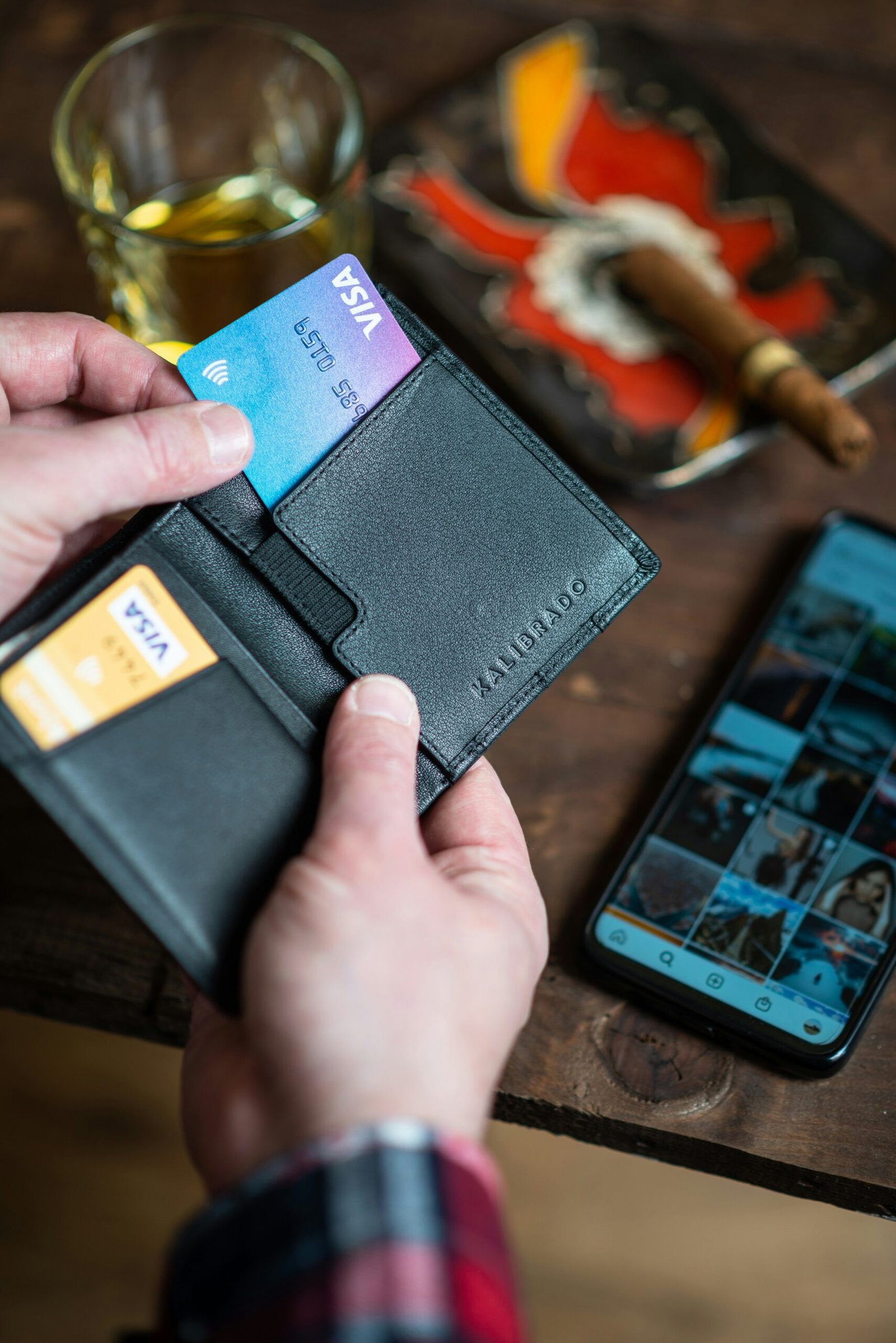 black leather bifold wallet on persons hand